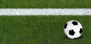 A soccer ball rolls behind the line